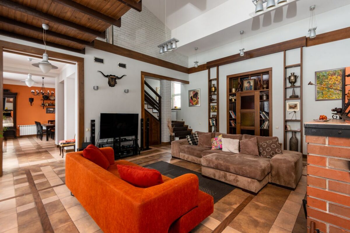 À propos Interior of contemporary spacious living room with sofas and TV set placed near wall with decorative elements in modern flat